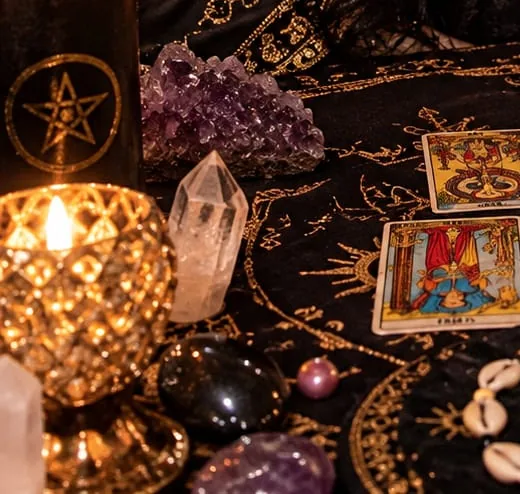Vela preta com pentagrama dourado, ametista e cristal de quartzo sobre o altar da Mãe Elza